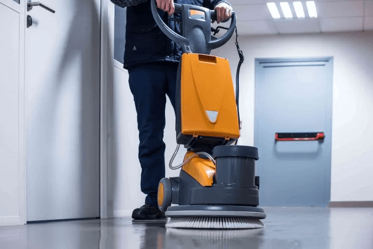Agent L&A Services passant la monobrosse sur le sol d'un couloir