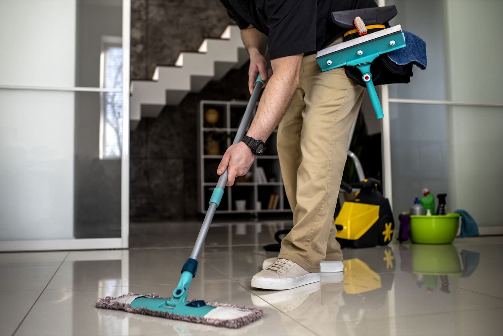 Agent L&A Services lavant le carrelage d'une villa au balai microfibre